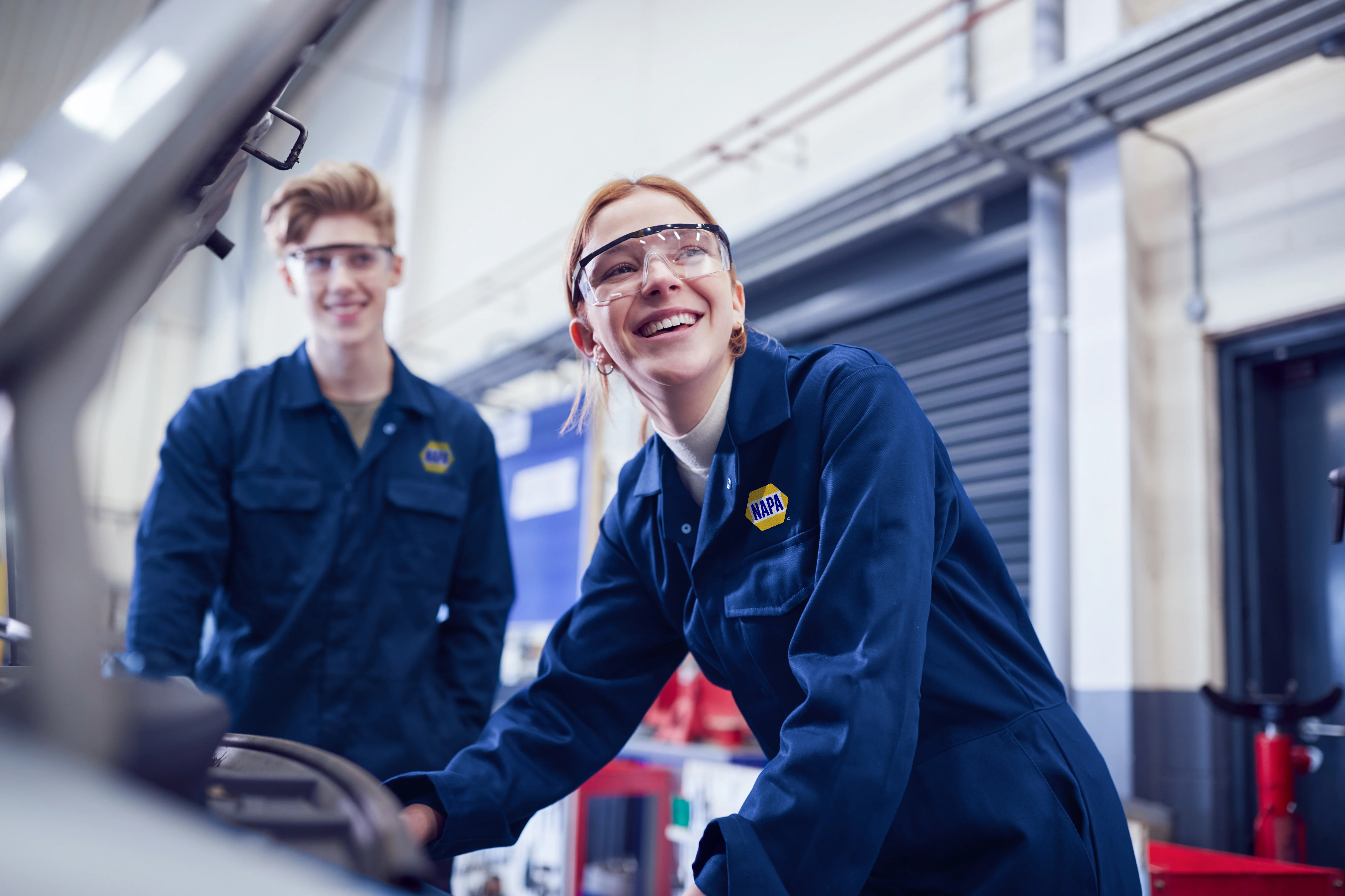 Students looking at car engine